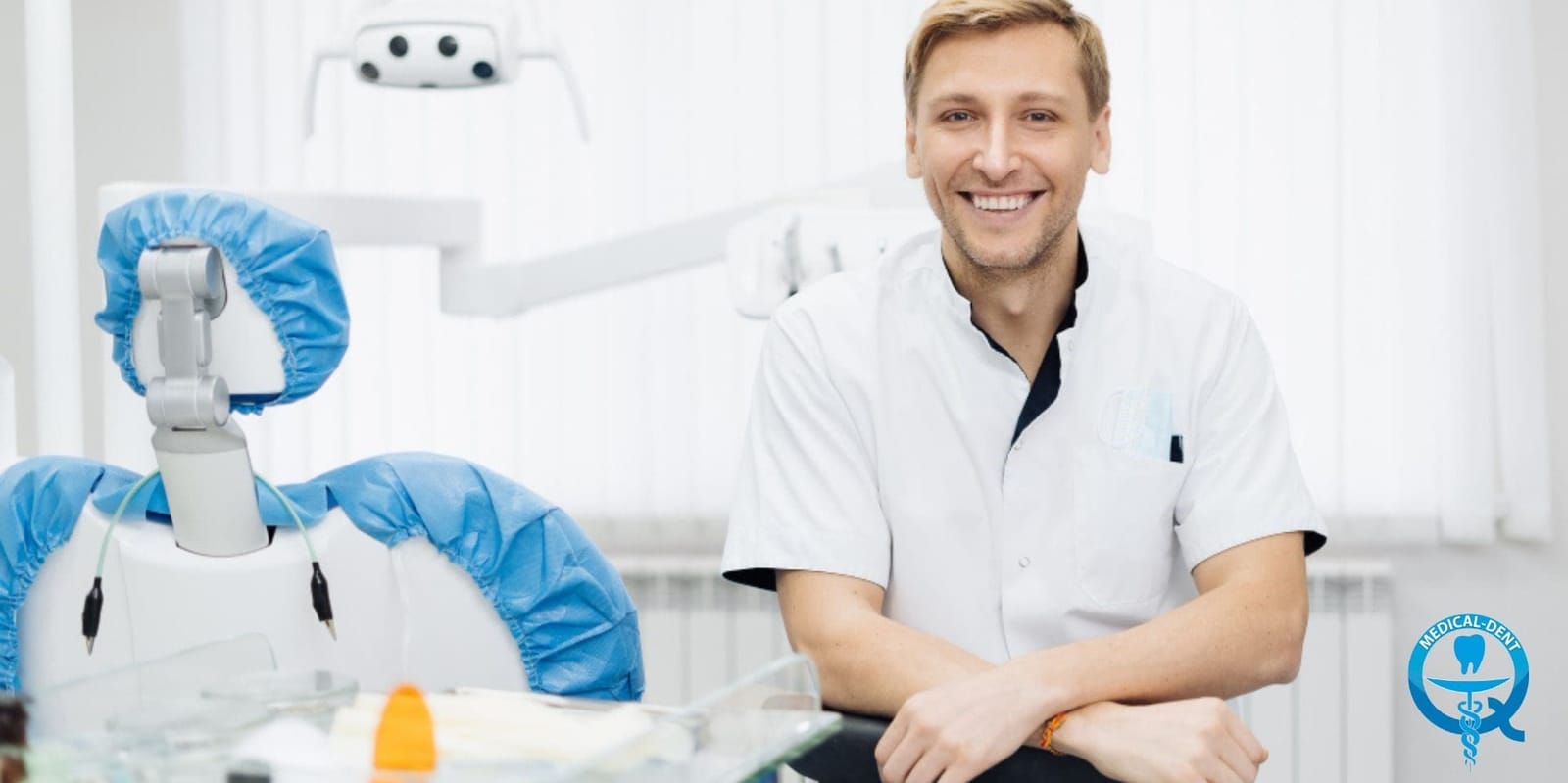 A clinician seated beside a dental chair