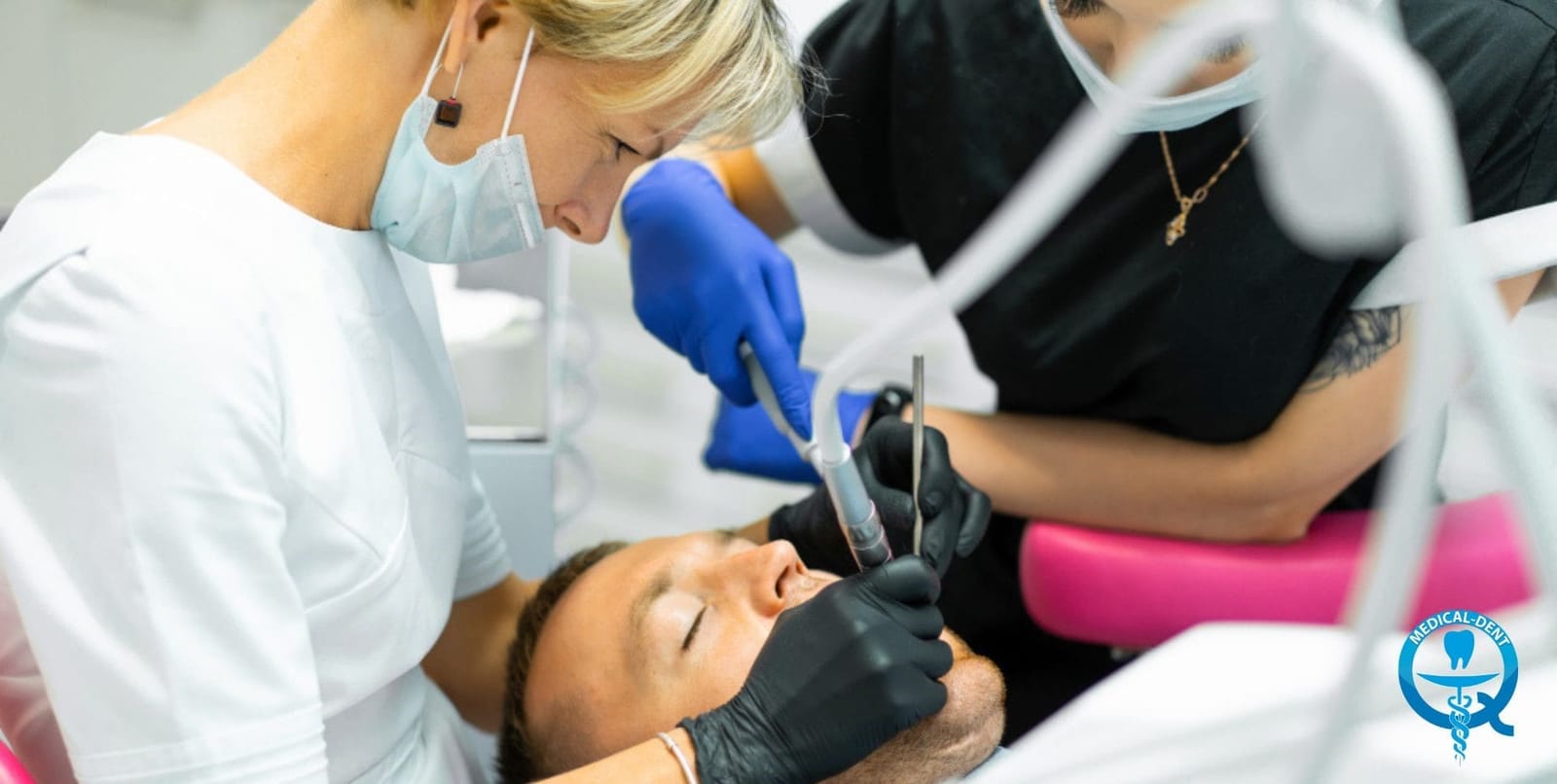 A dentist and assistant treating a patient in a dental chair