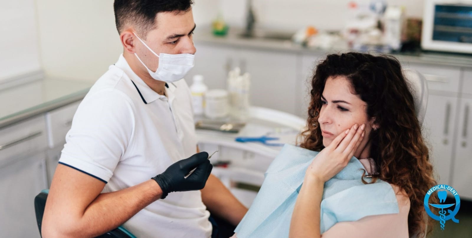 Dentist speaking with a patient who is holding her jaw