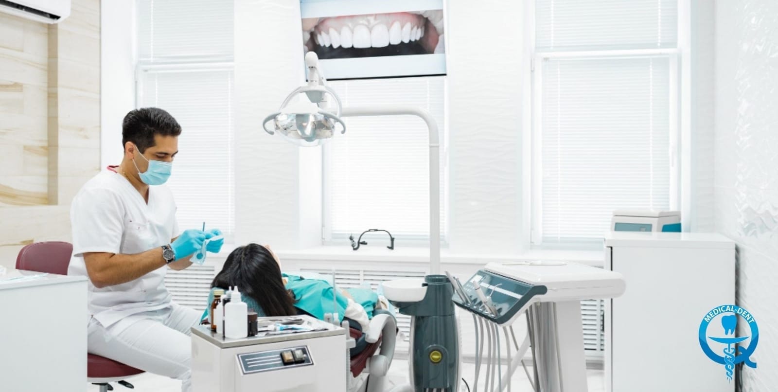 A clinician beside a patient in a dental chair
