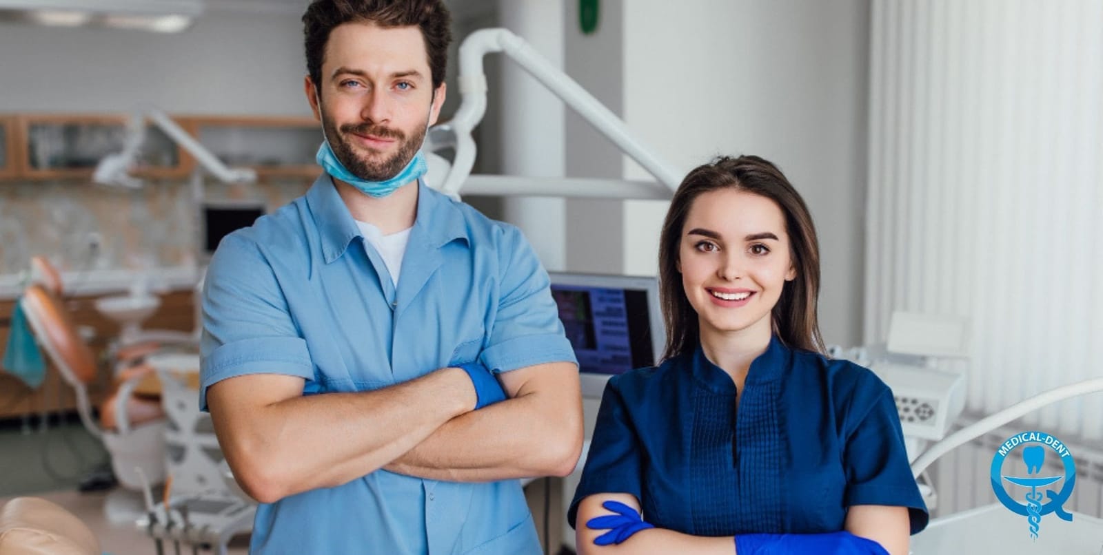 Two people in clinical clothing standing in a dental surgery