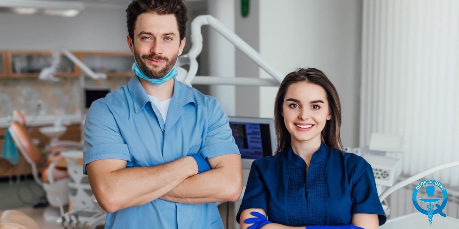 Two members of a dental team wearing blue scrubs