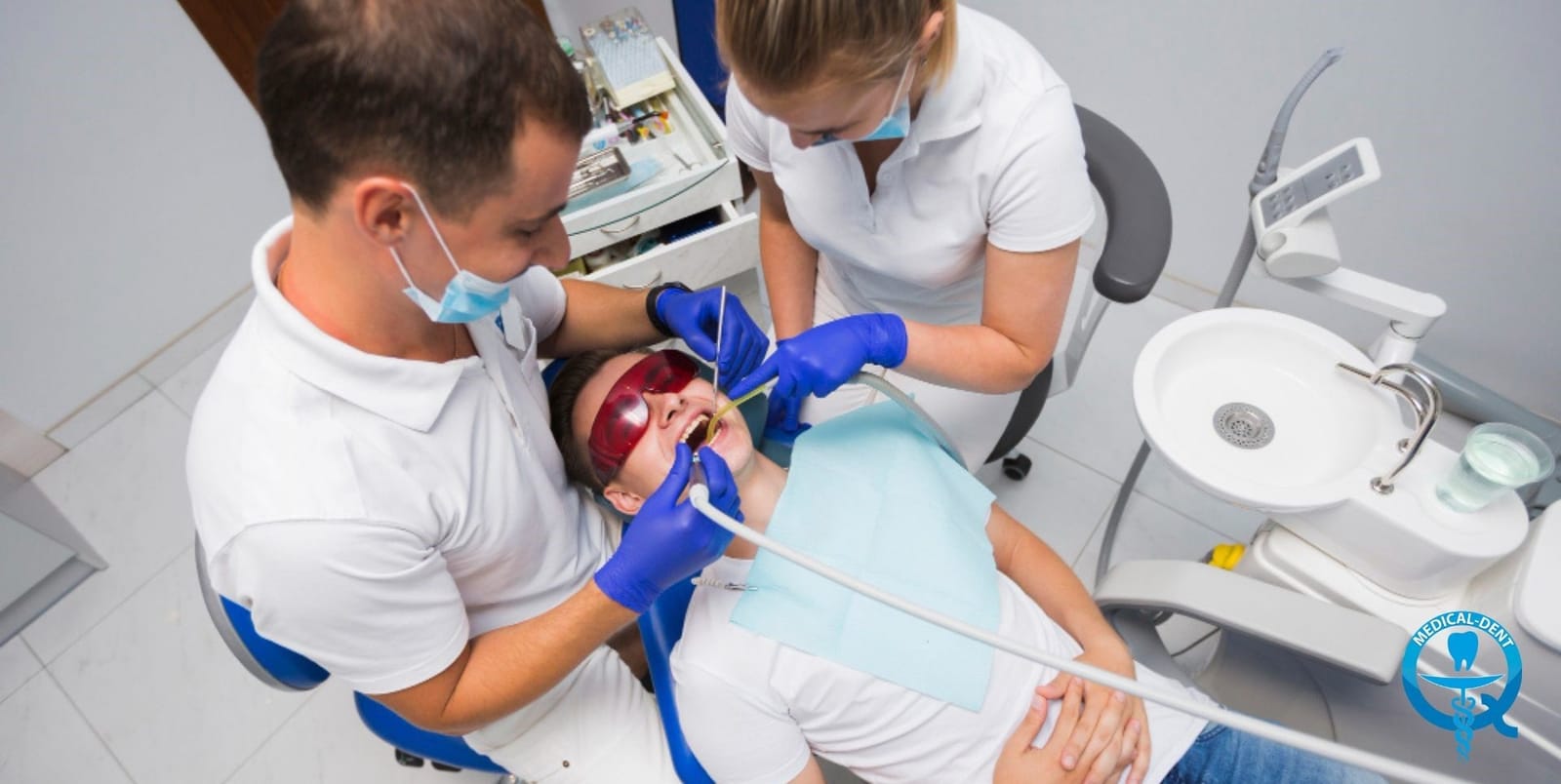 A dental team treating a patient in a dental chair