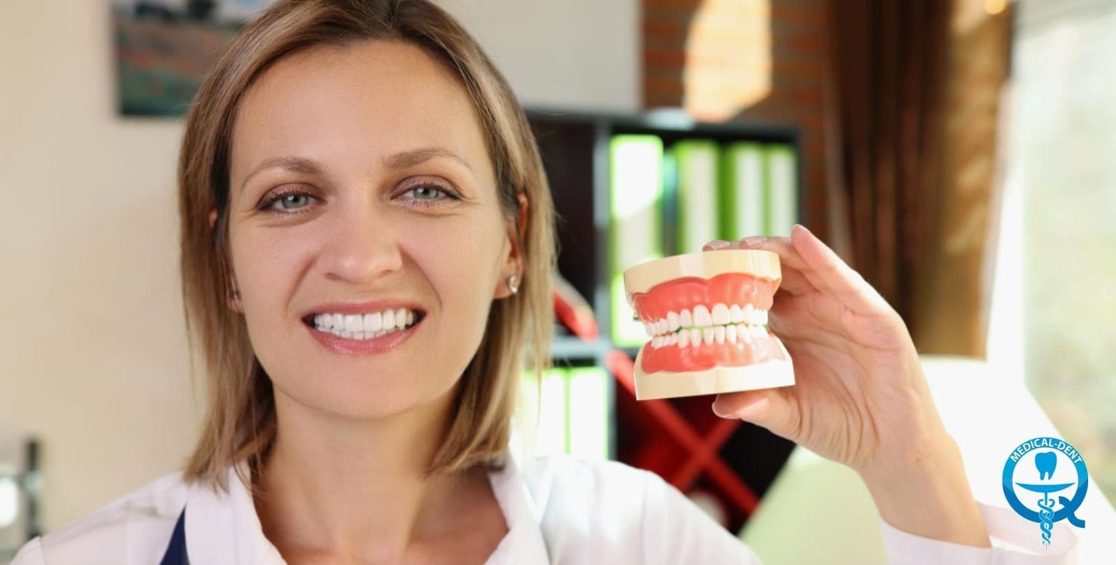 A woman holding a model of teeth and gums