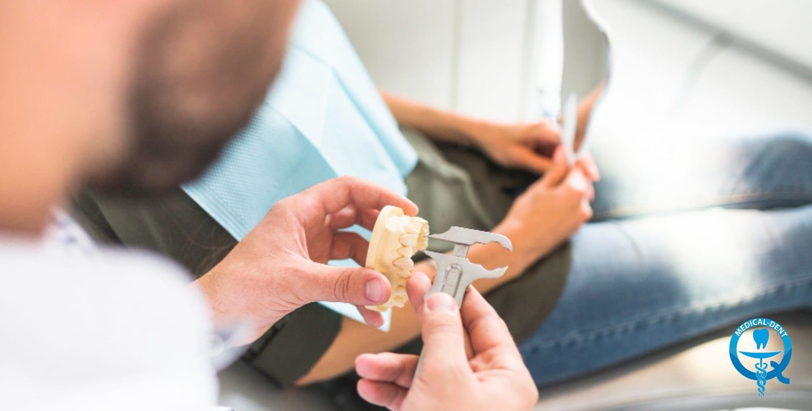 A dentist showing a partial denture to a patient