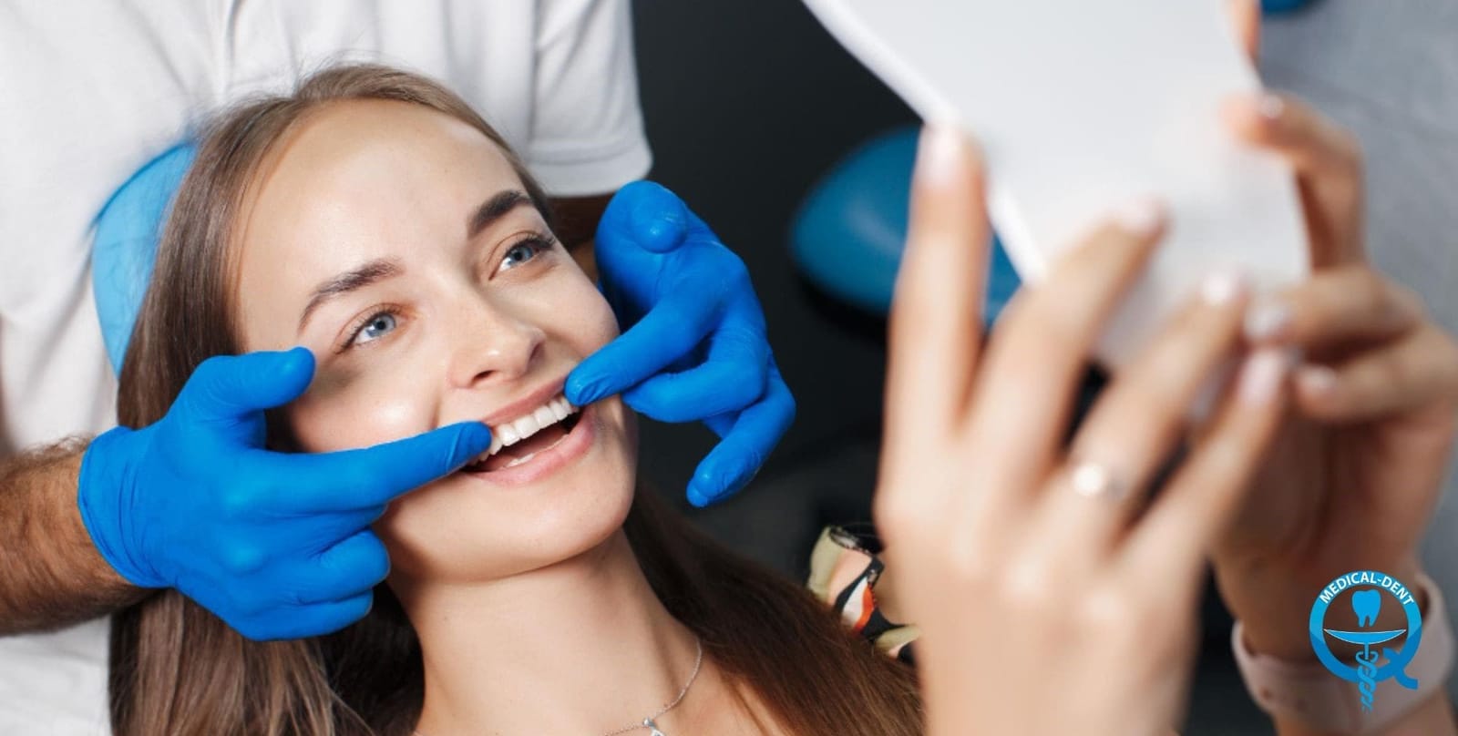 A patient looking in a mirror while a clinician shows her teeth