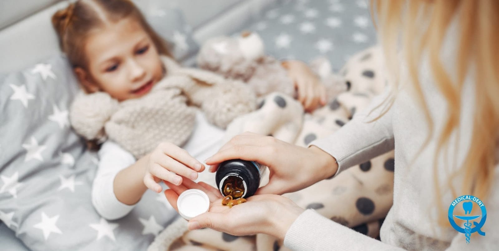 An adult holding a bottle beside a child resting with a soft toy
