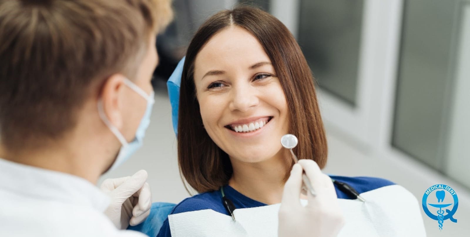 A patient looking at her teeth in a hand mirror