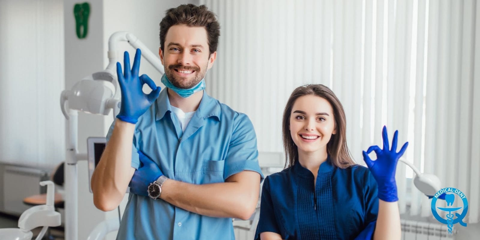 Two dental professionals wearing blue gloves in a practice