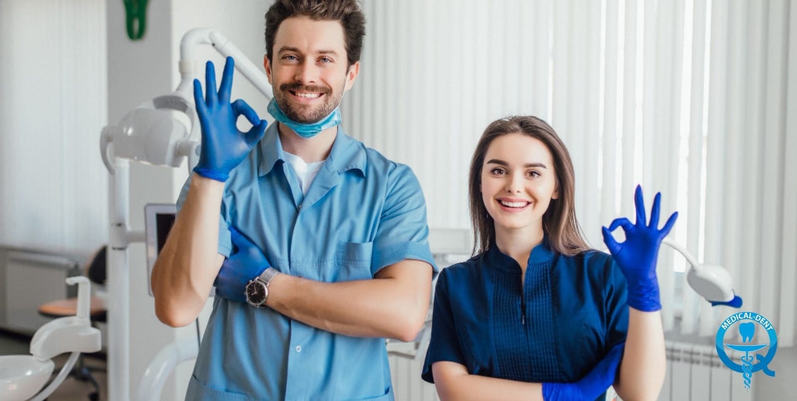 Two people in dental uniforms making an OK gesture