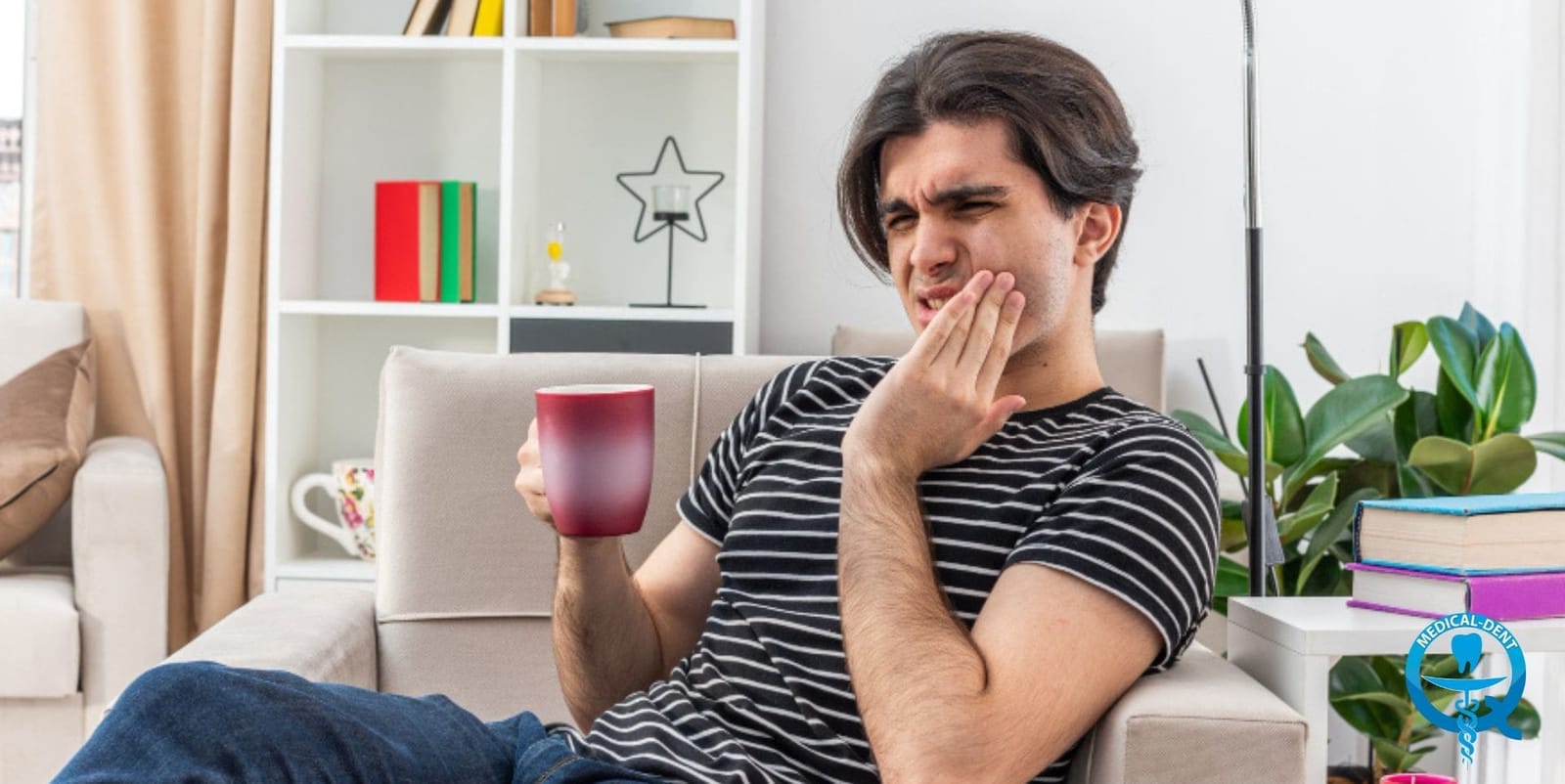 A person holding a mug and touching their cheek