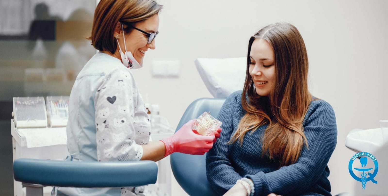 A dental professional showing a model of teeth to a patient