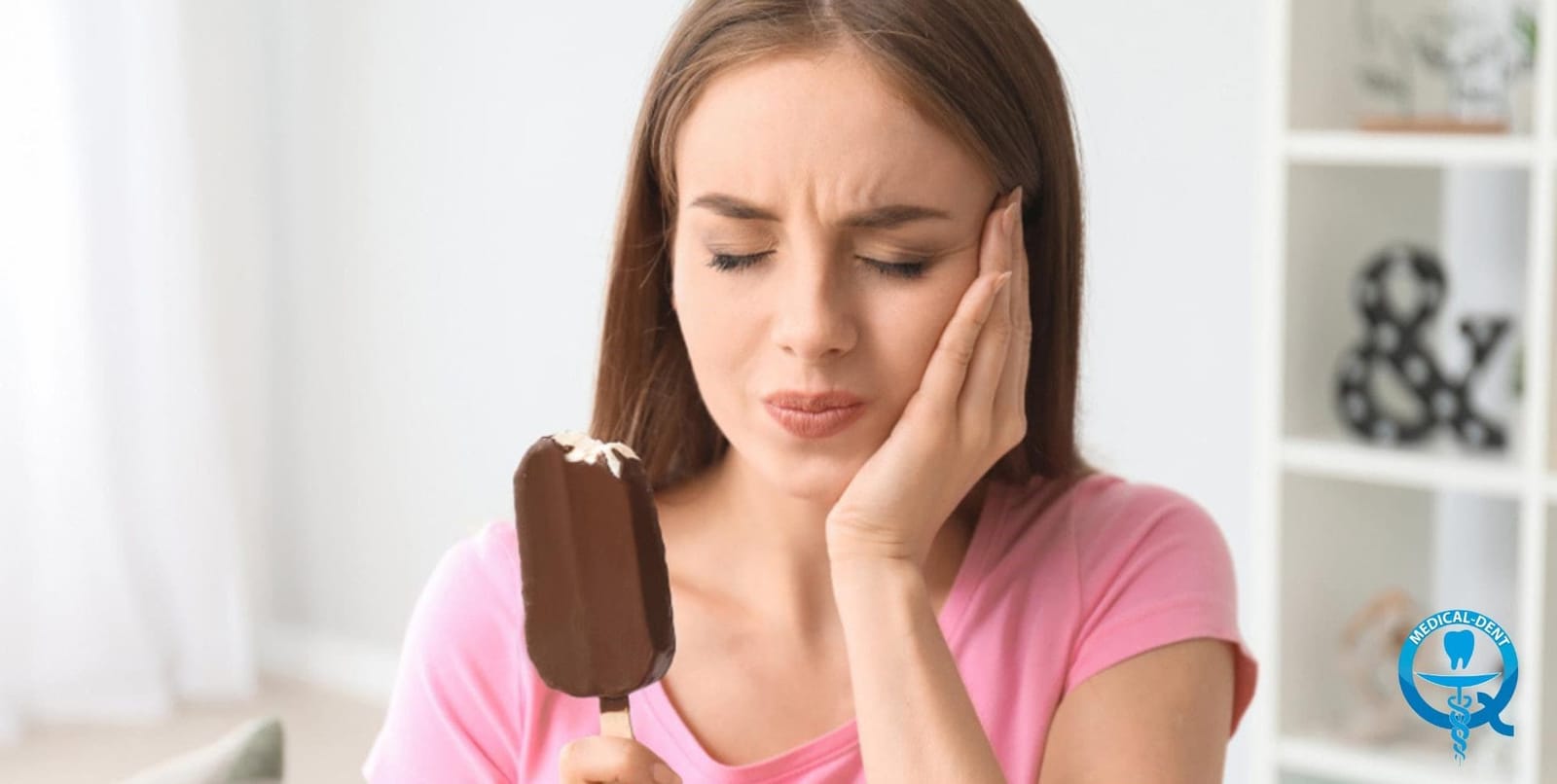 A woman holding an ice cream and touching her cheek