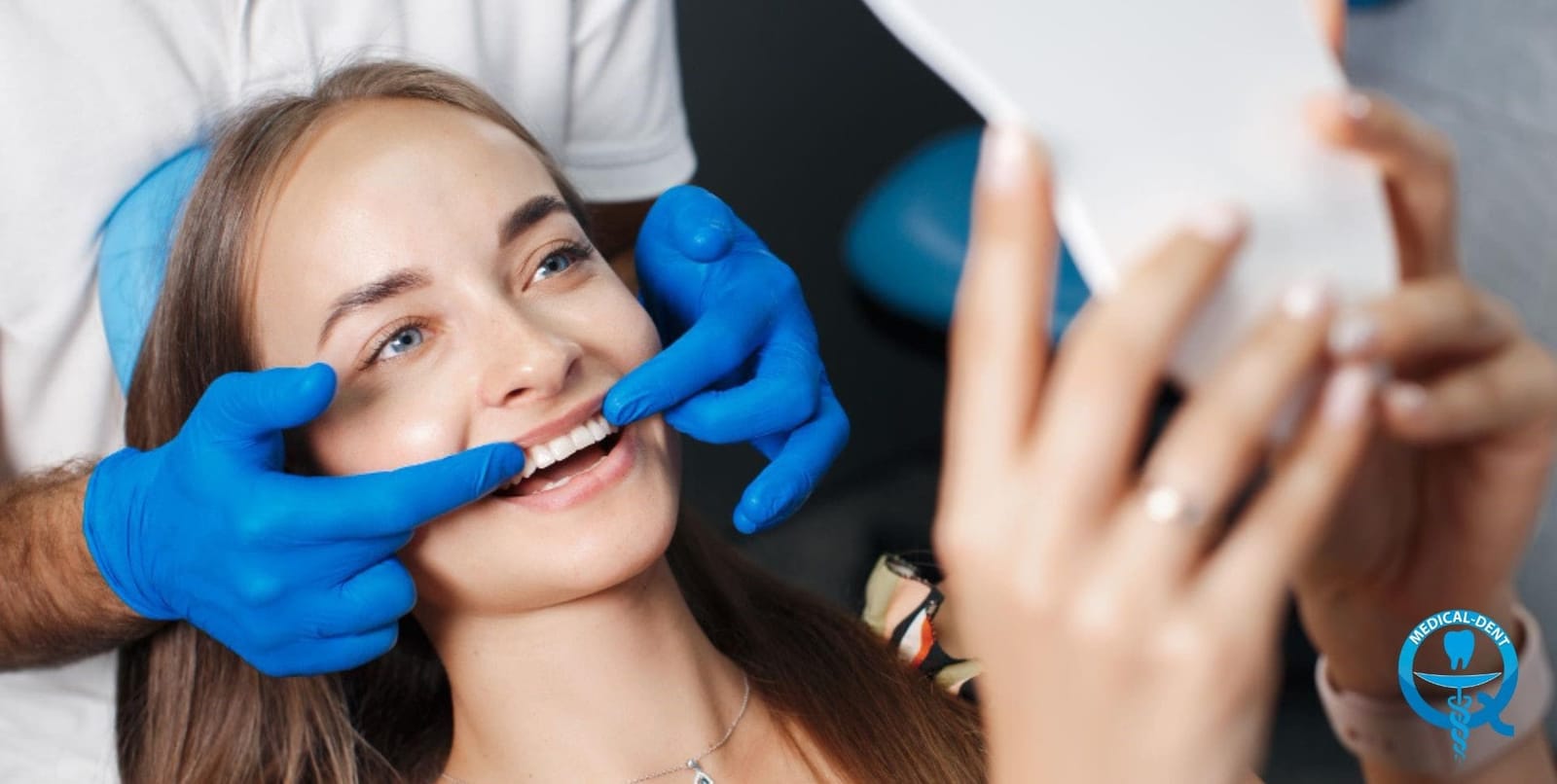 A patient looking in a hand mirror during a dental appointment