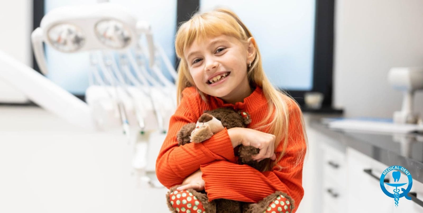 Child holding a soft toy in a dental surgery