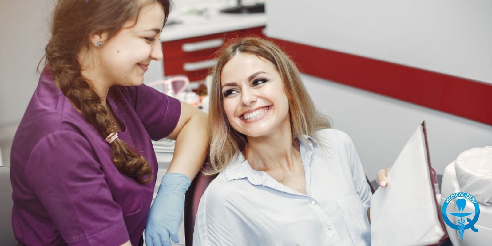 A patient holding a mirror beside a member of the dental team