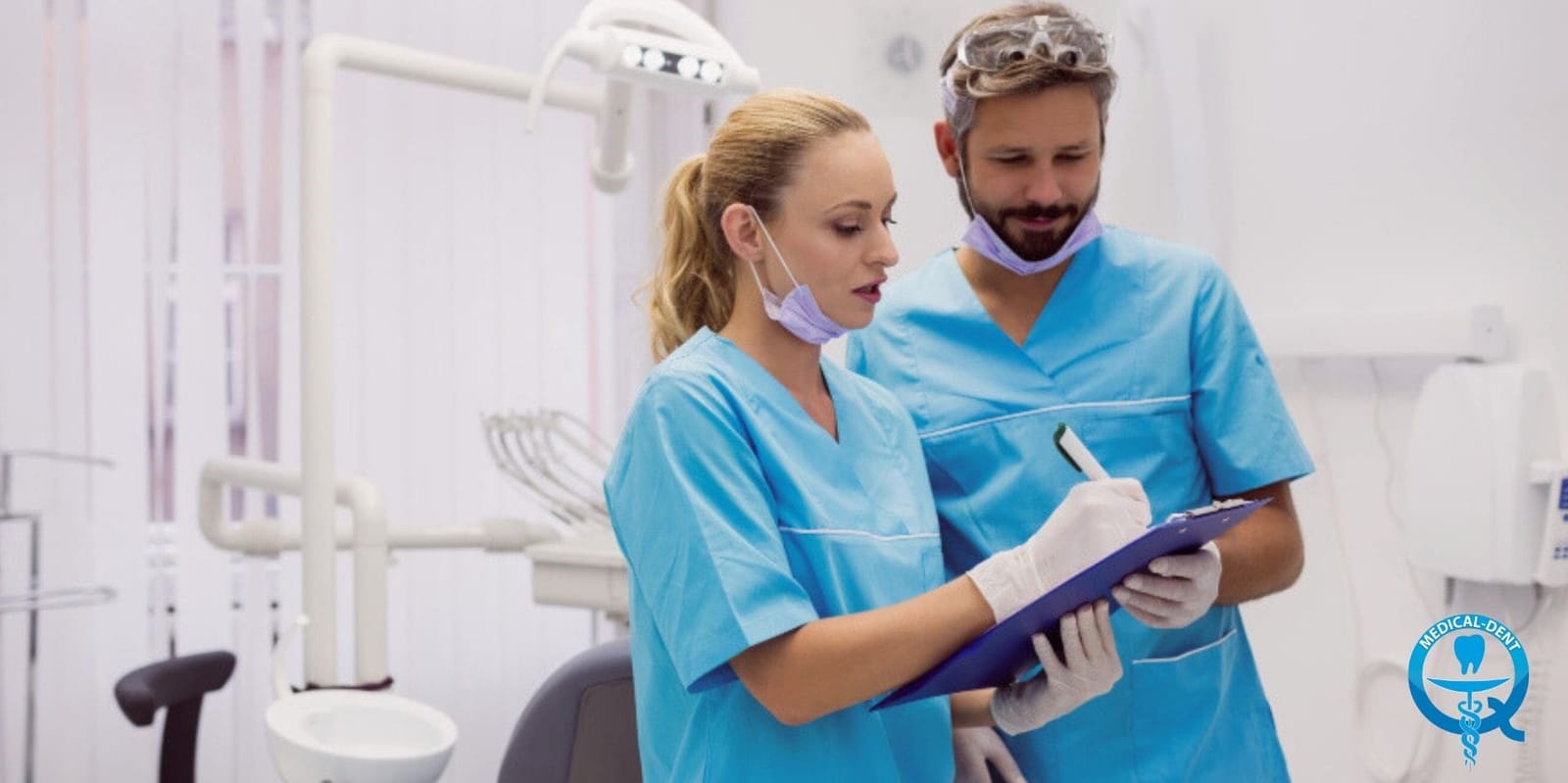 Two dental clinicians looking at a clipboard