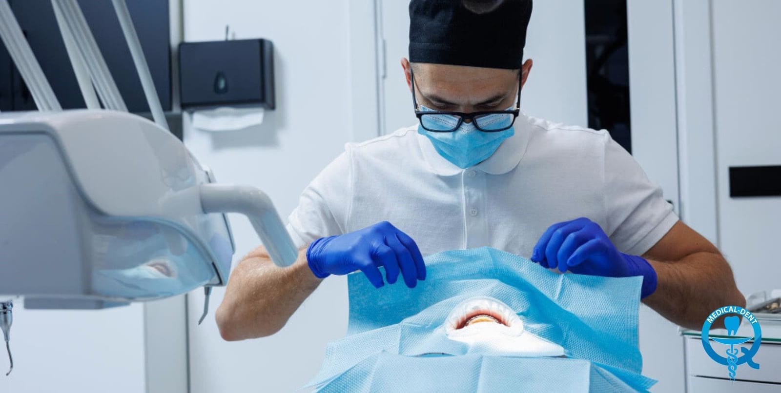 A clinician arranging a drape around a patient before dental treatment