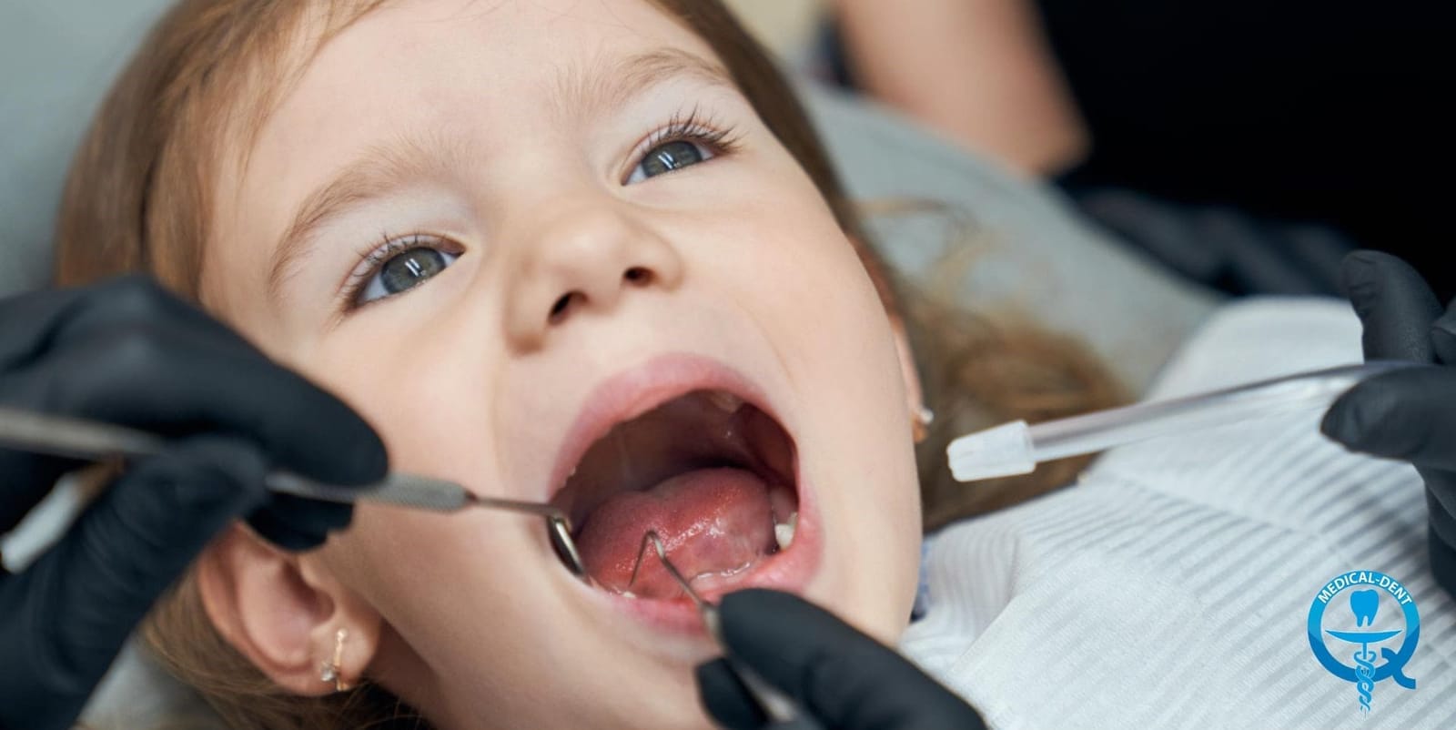 Child having a tooth examined with dental instruments
