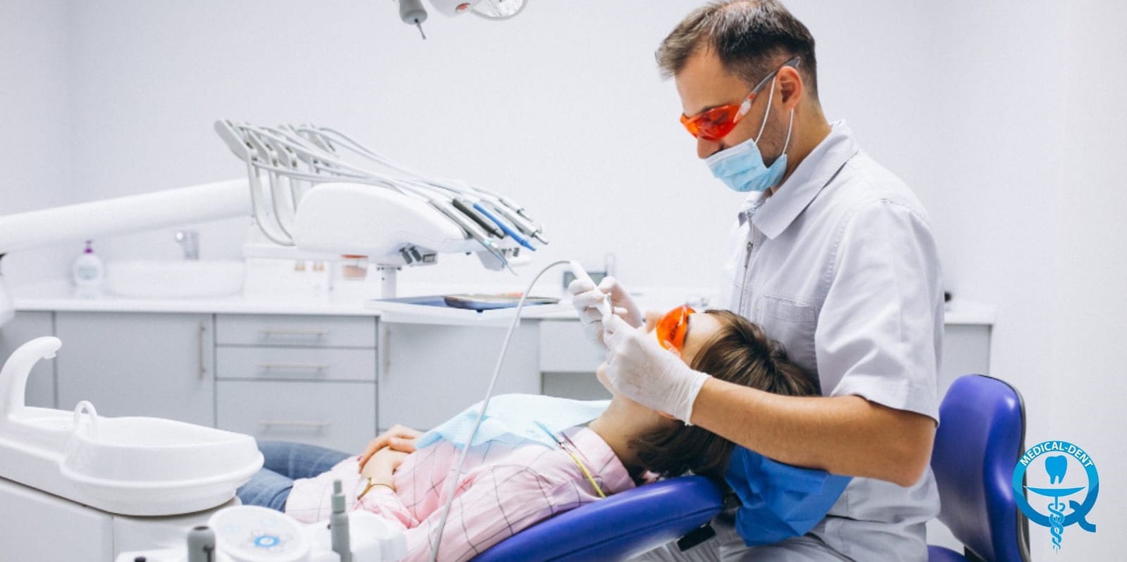 A dental professional working beside a patient