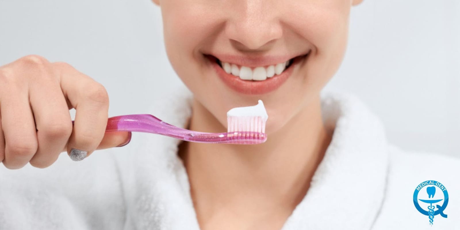 A person holding a toothbrush beside their smile