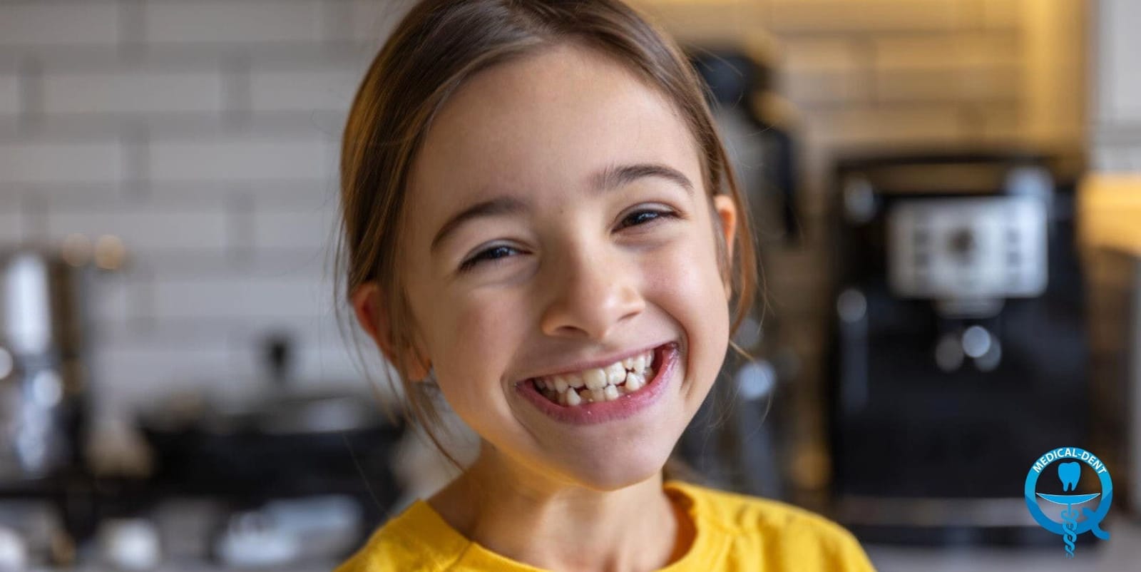 A smiling girl wearing a yellow top