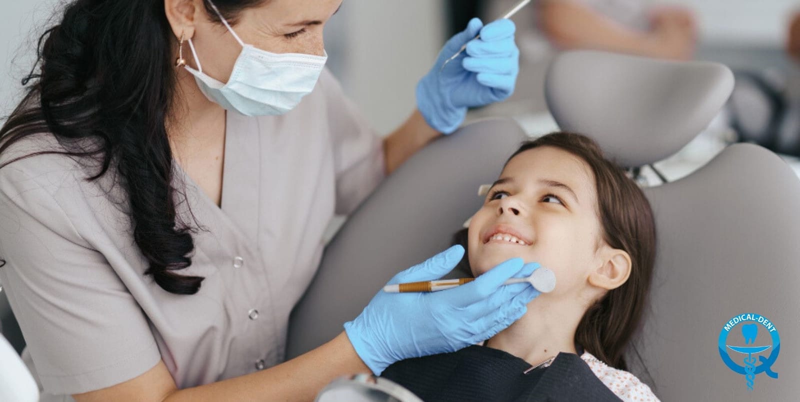 A clinician examining a girl in a dental chair