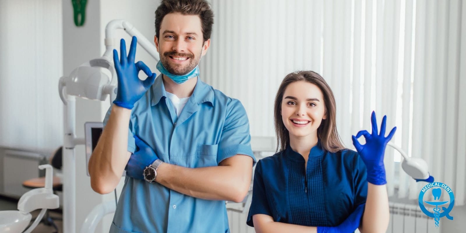 Two dental team members in blue uniforms