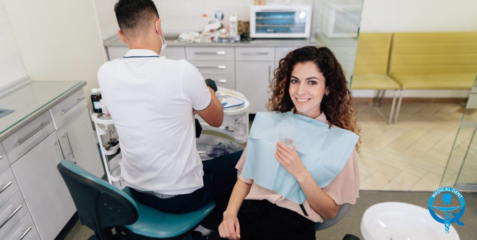 A patient seated in a dental chair beside a clinician