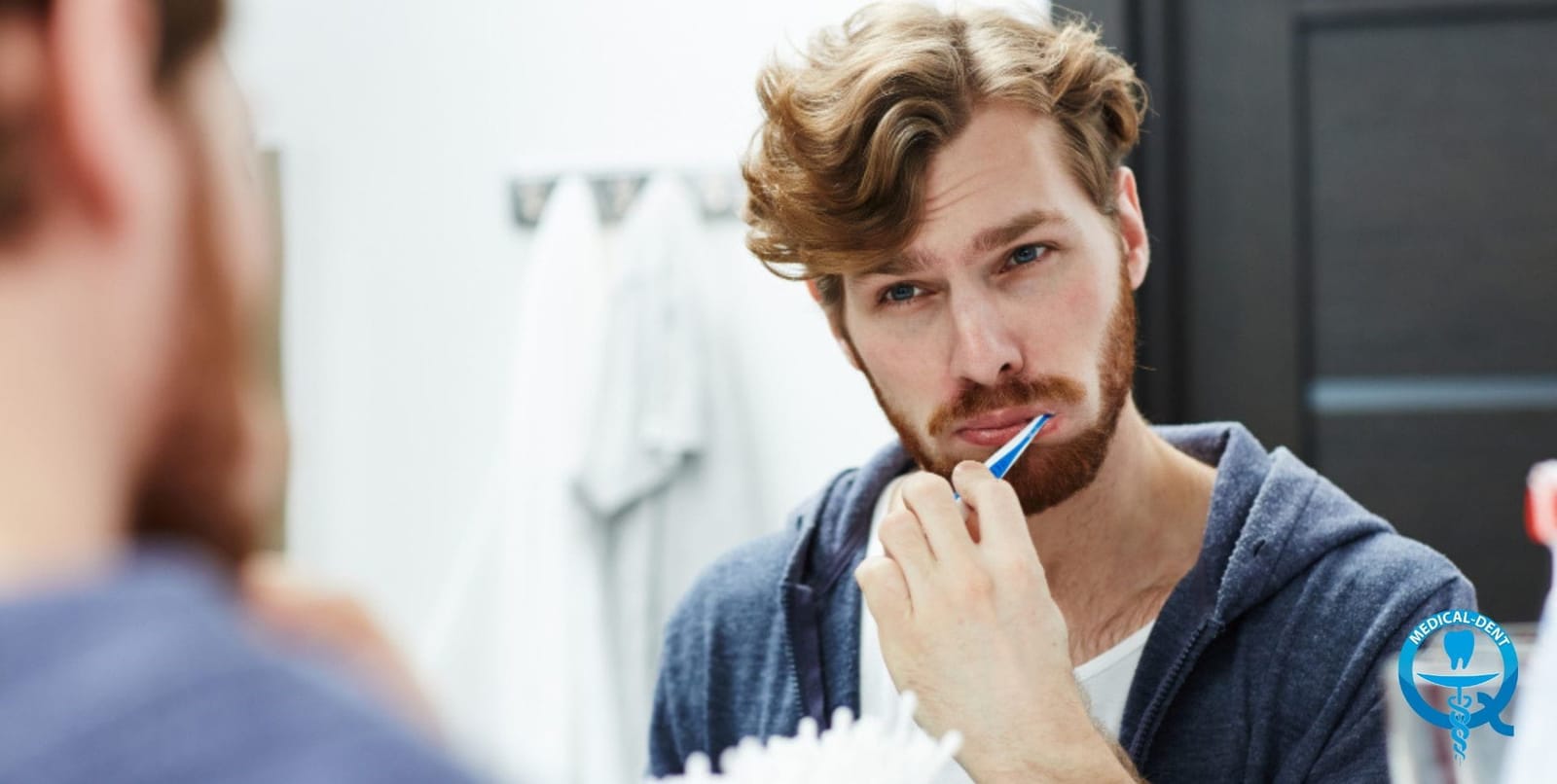 Man brushing his teeth in front of a mirror